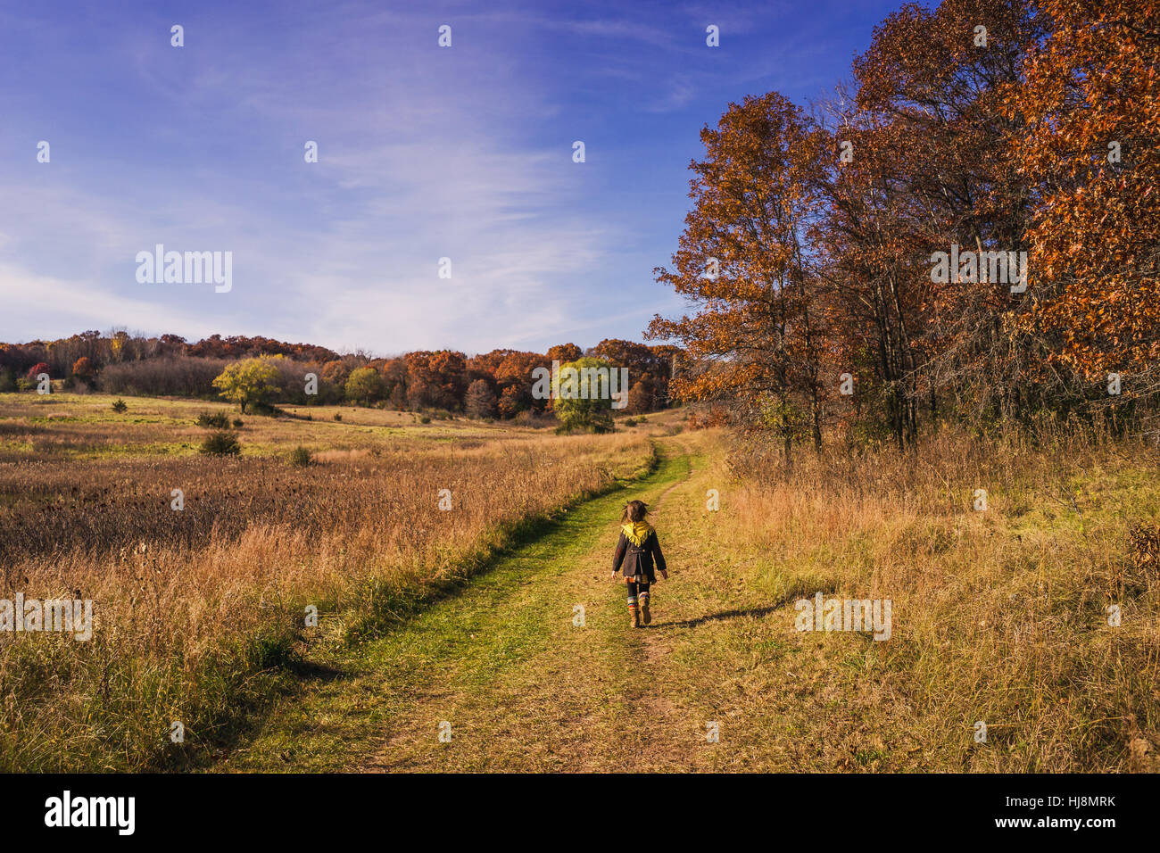 Girl walking along nature trail in autumn Stock Photo