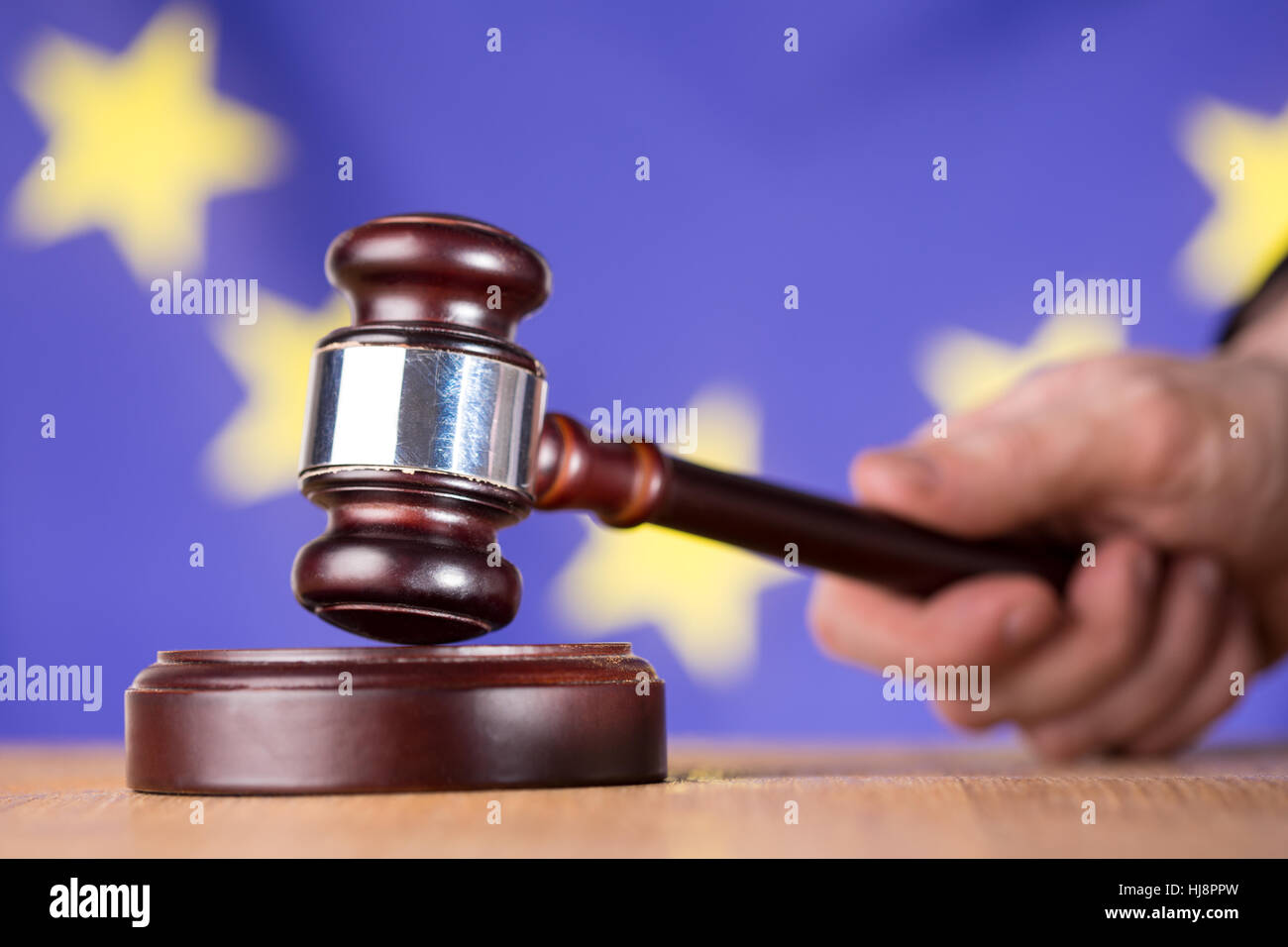 Hand banging gavel on sounding block on european union flag background Stock Photo