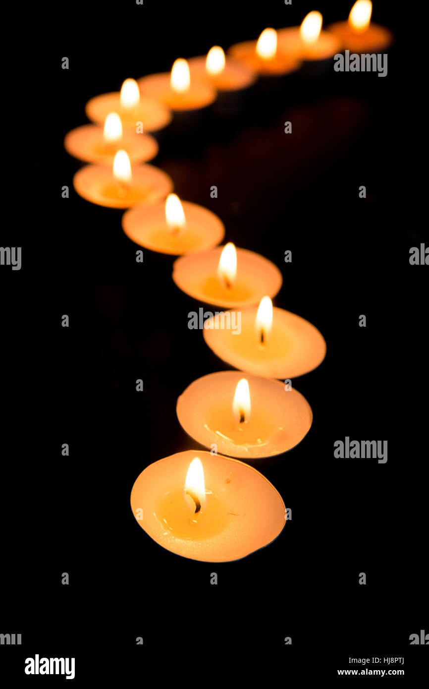 Tealight candles lighting in a curved line in the dark Stock Photo Alamy