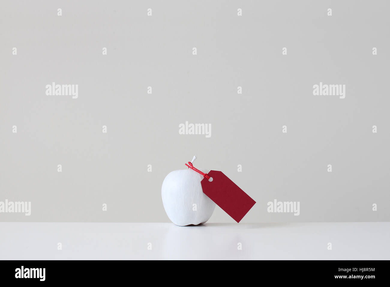 White painted apple with red tag Stock Photo