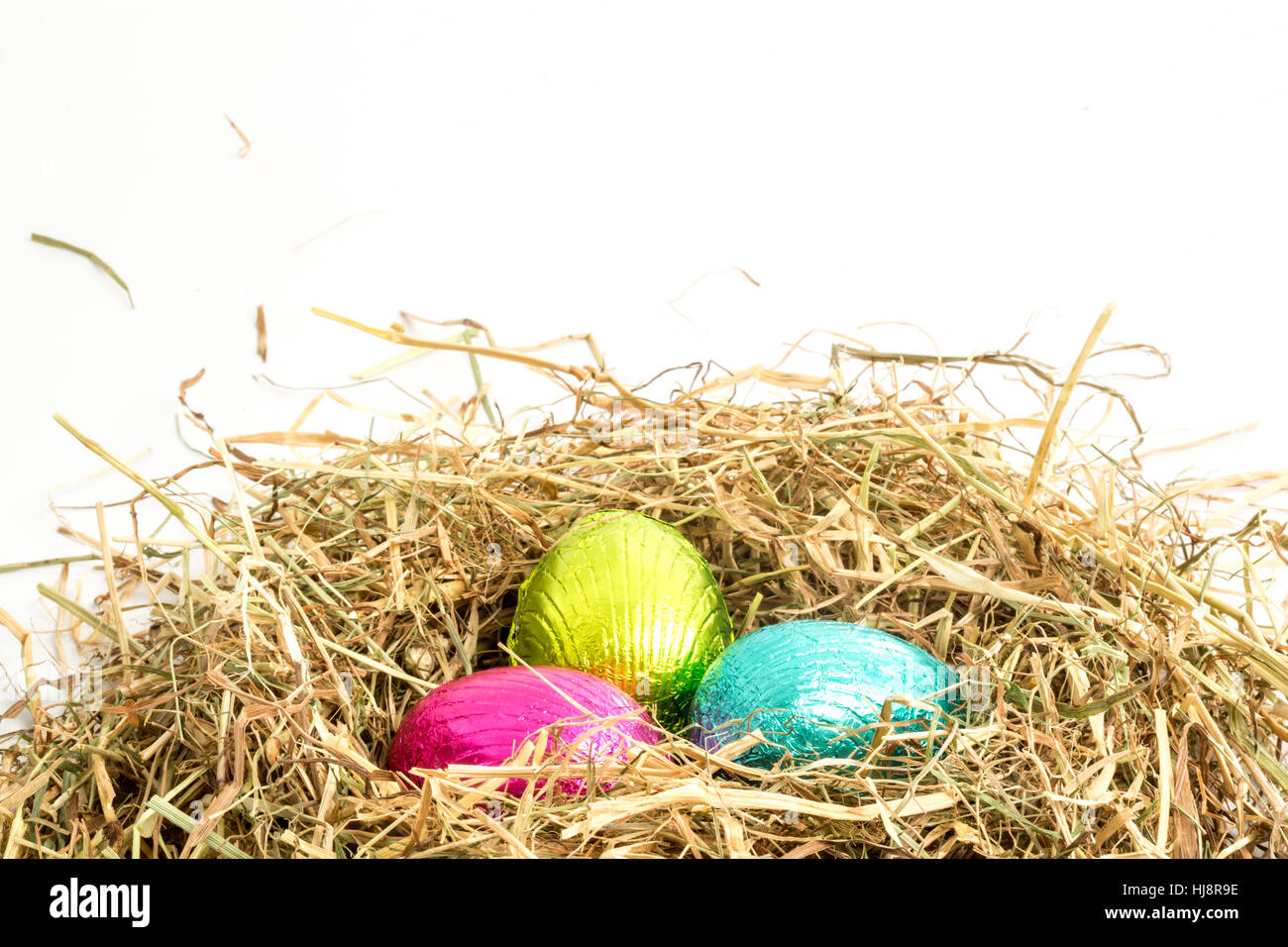 Three easter eggs nestled in straw nest with copy space Stock Photo - Alamy