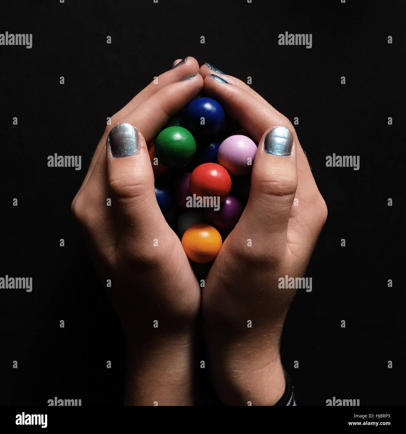 Girl's hands holding marbles Stock Photo