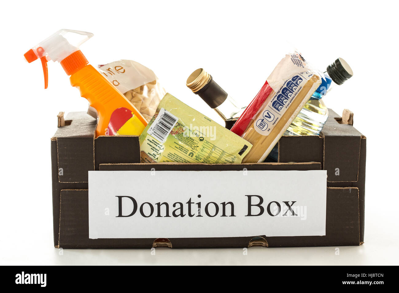 Black cardboard donation box with houseware product and food on white