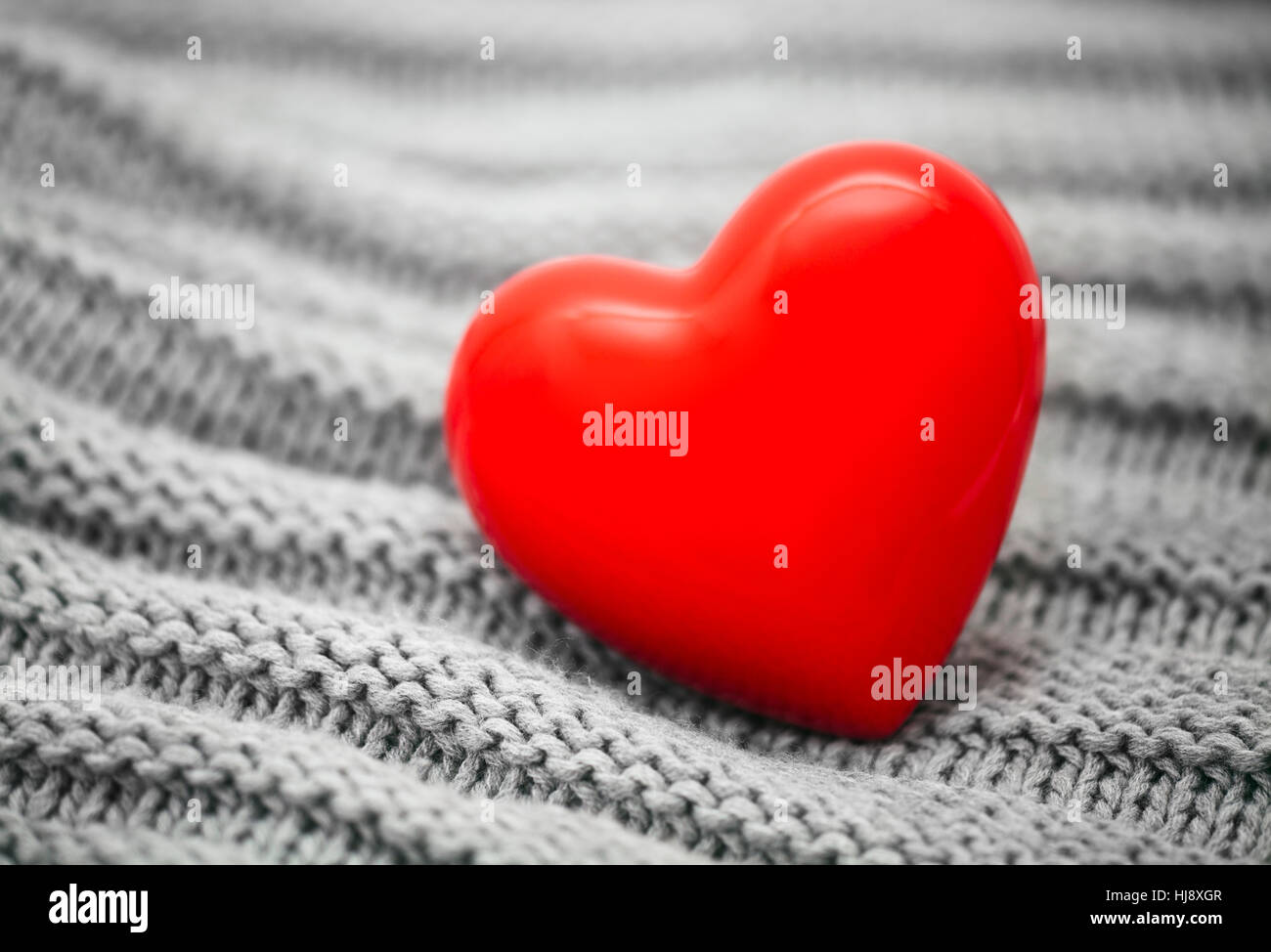 Small red heart on knitted wool background Stock Photo