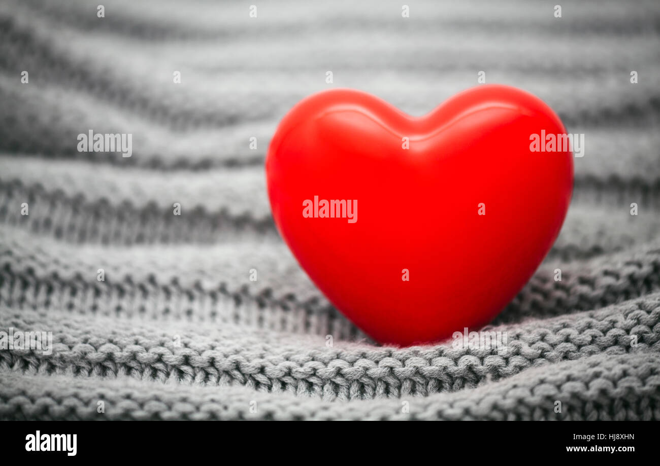 Small red heart on knitted wool background Stock Photo