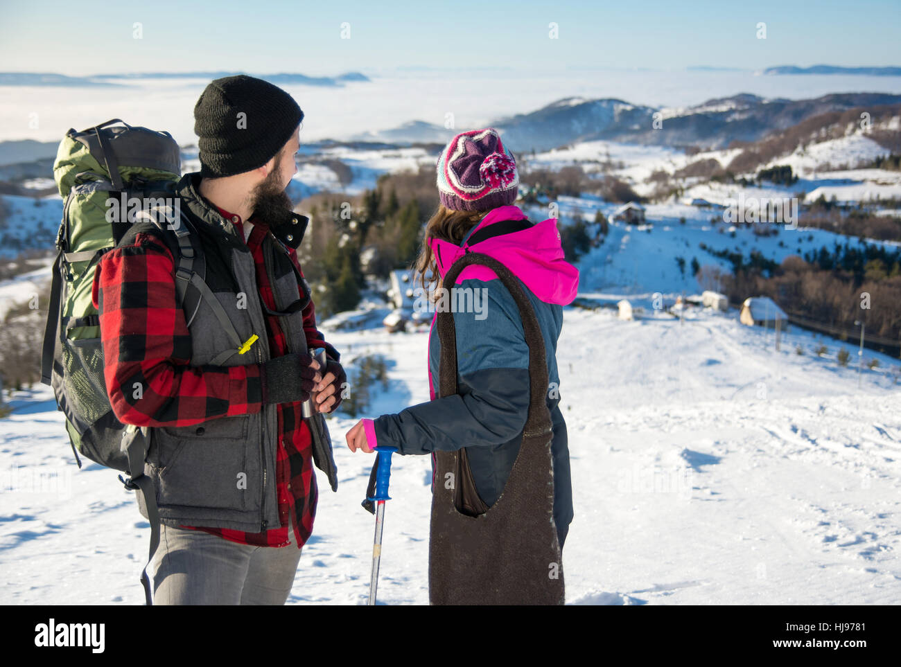 Couple of hikers standing on the mountain pick on the winter day Stock Photo