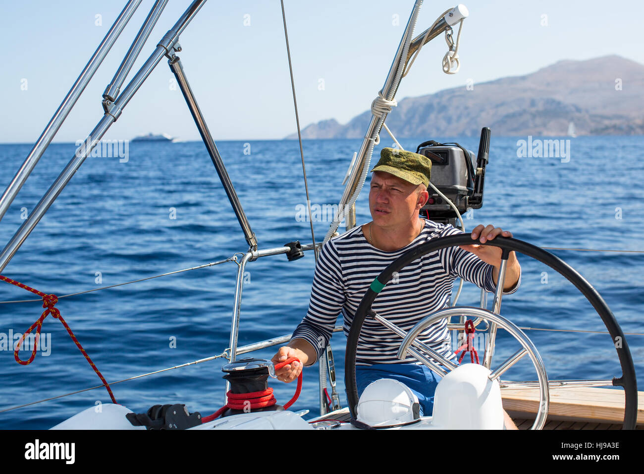 Man at the helm sail boat, the ship controls during sea yacht race