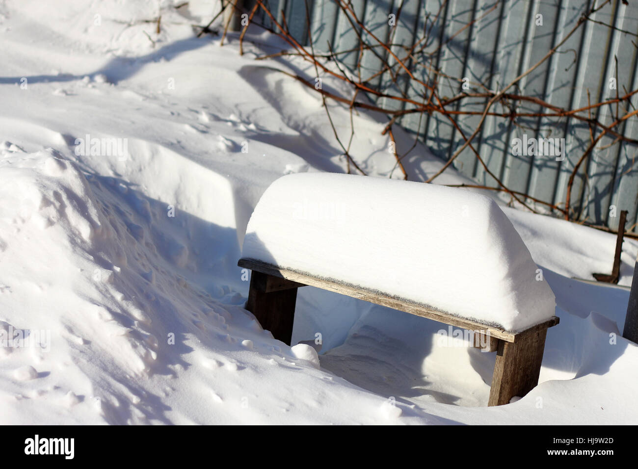 White snow and small bench under snowdrift close up Stock Photo