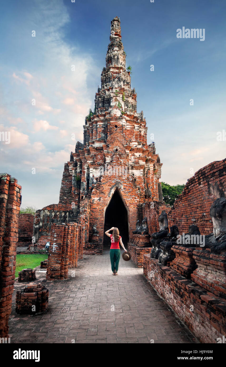 Woman tourist with hat looking at ancient ruined wat Chaiwatthanaram in Ayutthaya, Thailand Stock Photo