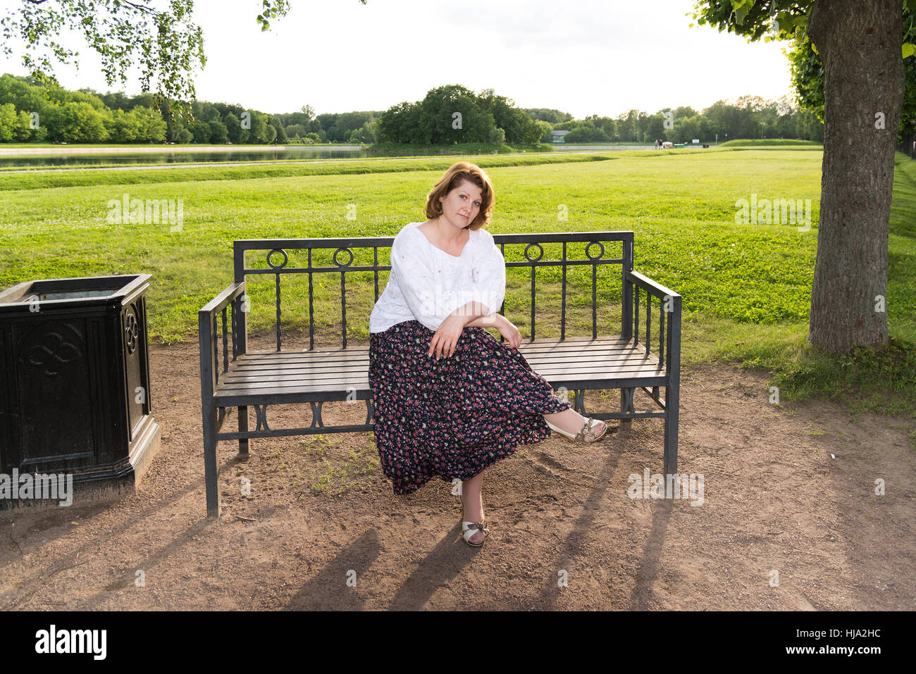 woman sitting on bench in summer park Stock Photo