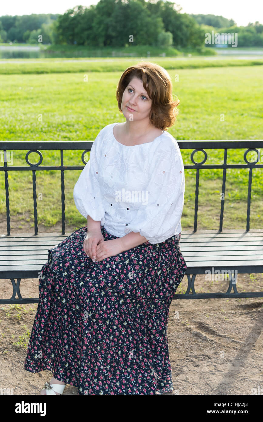 woman sitting on bench in summer park Stock Photo - Alamy