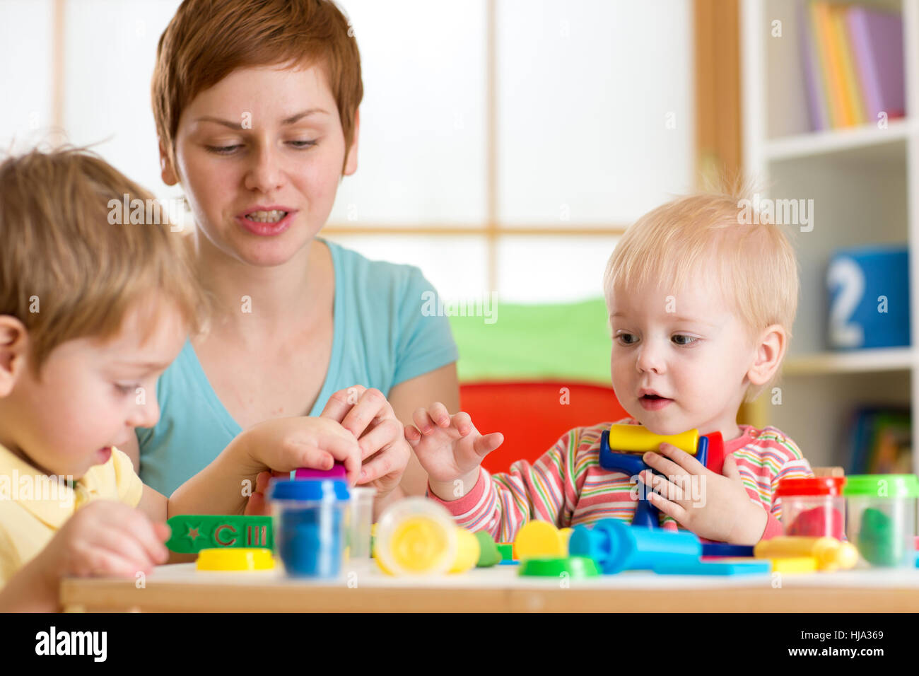 Kids playing with play clay at home, kindergarten or playschool Stock