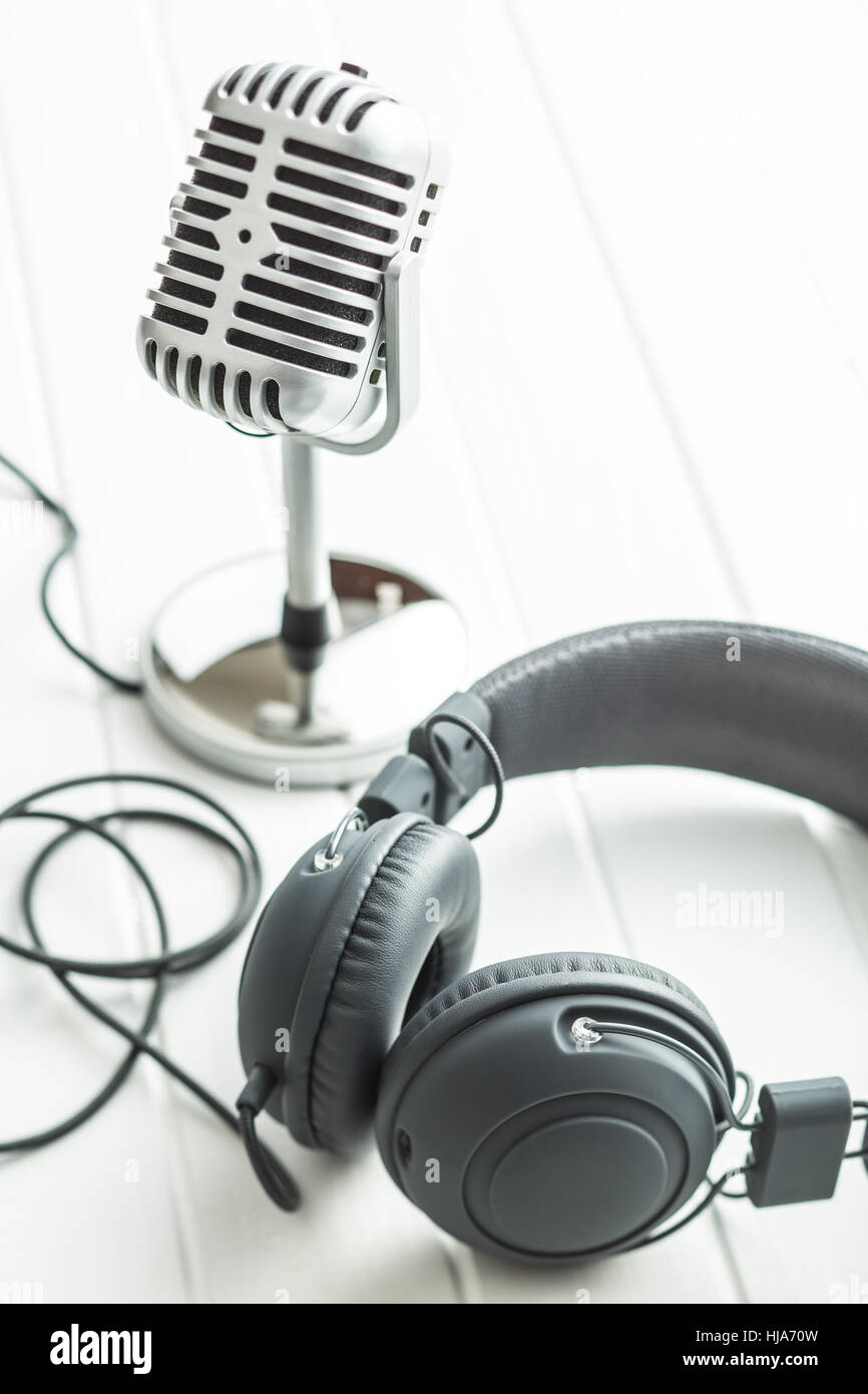 Headphones and microphone on white table. Stock Photo