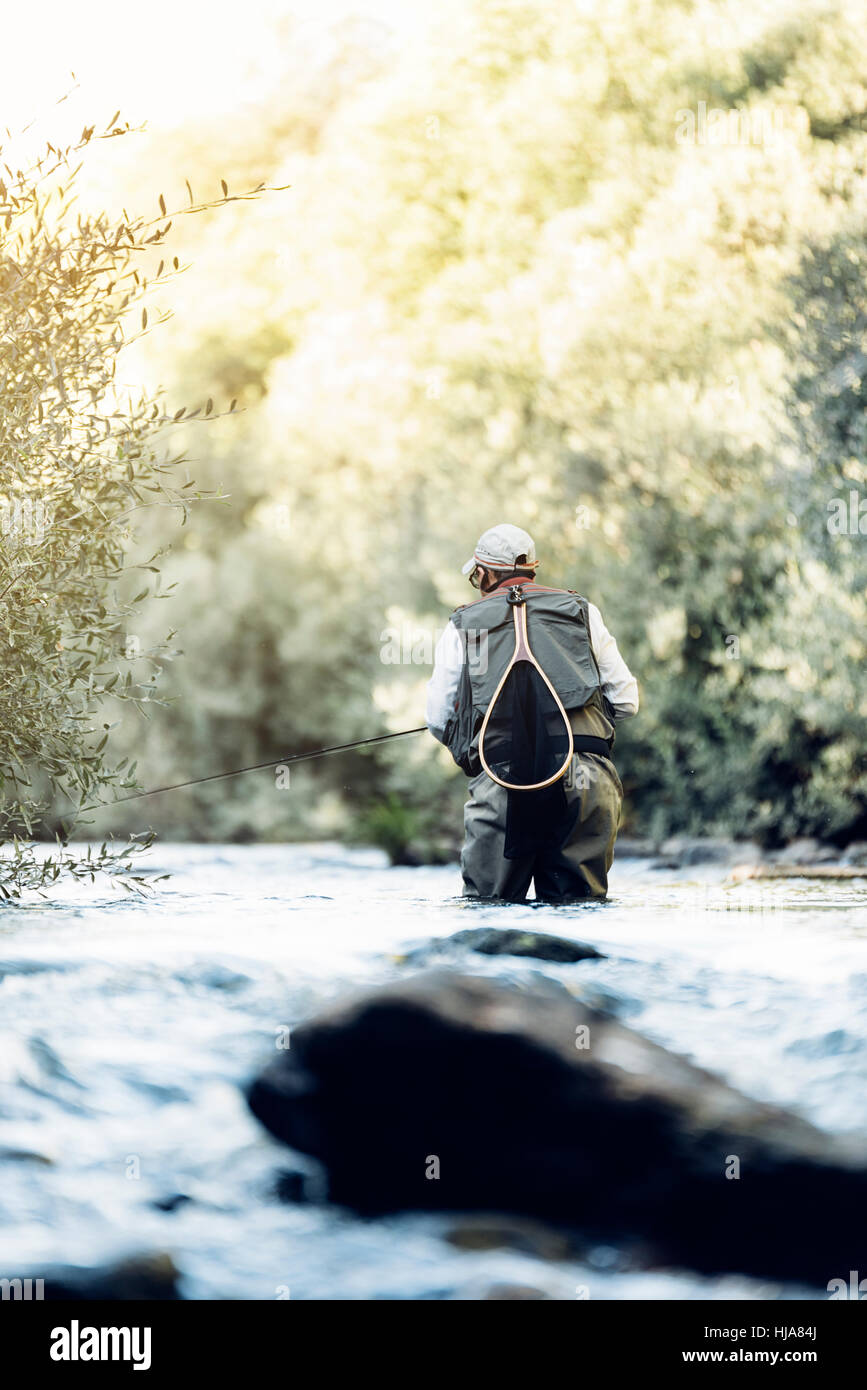 Fly fisherman using flyfishing rod in beautiful river. Stock Photo