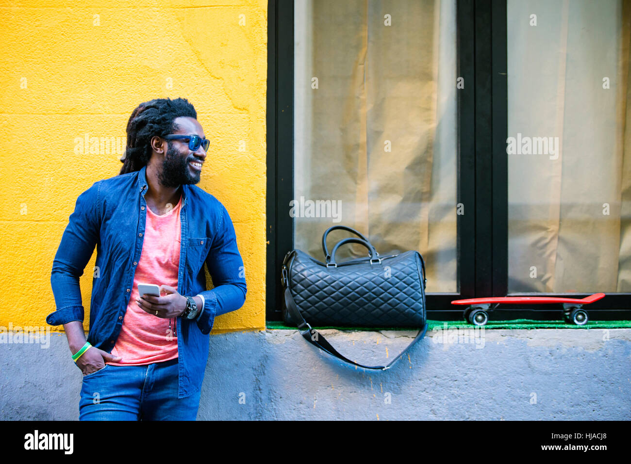 Outdoor Portrait Of Handsome African Young Man Using Mobile In The ...