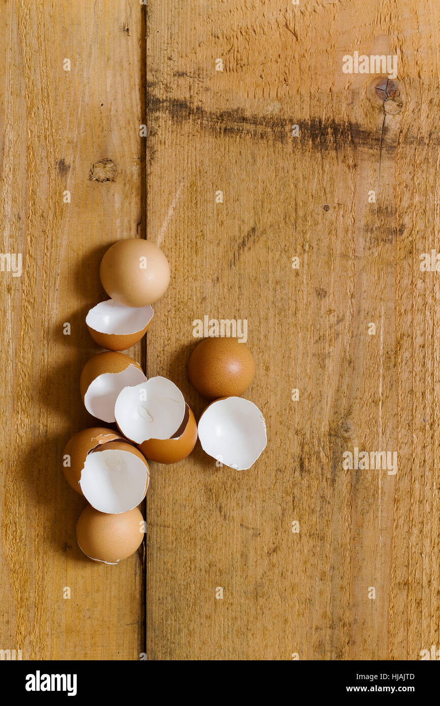 Several broken eggs on a rustic wooden board - background image with ...