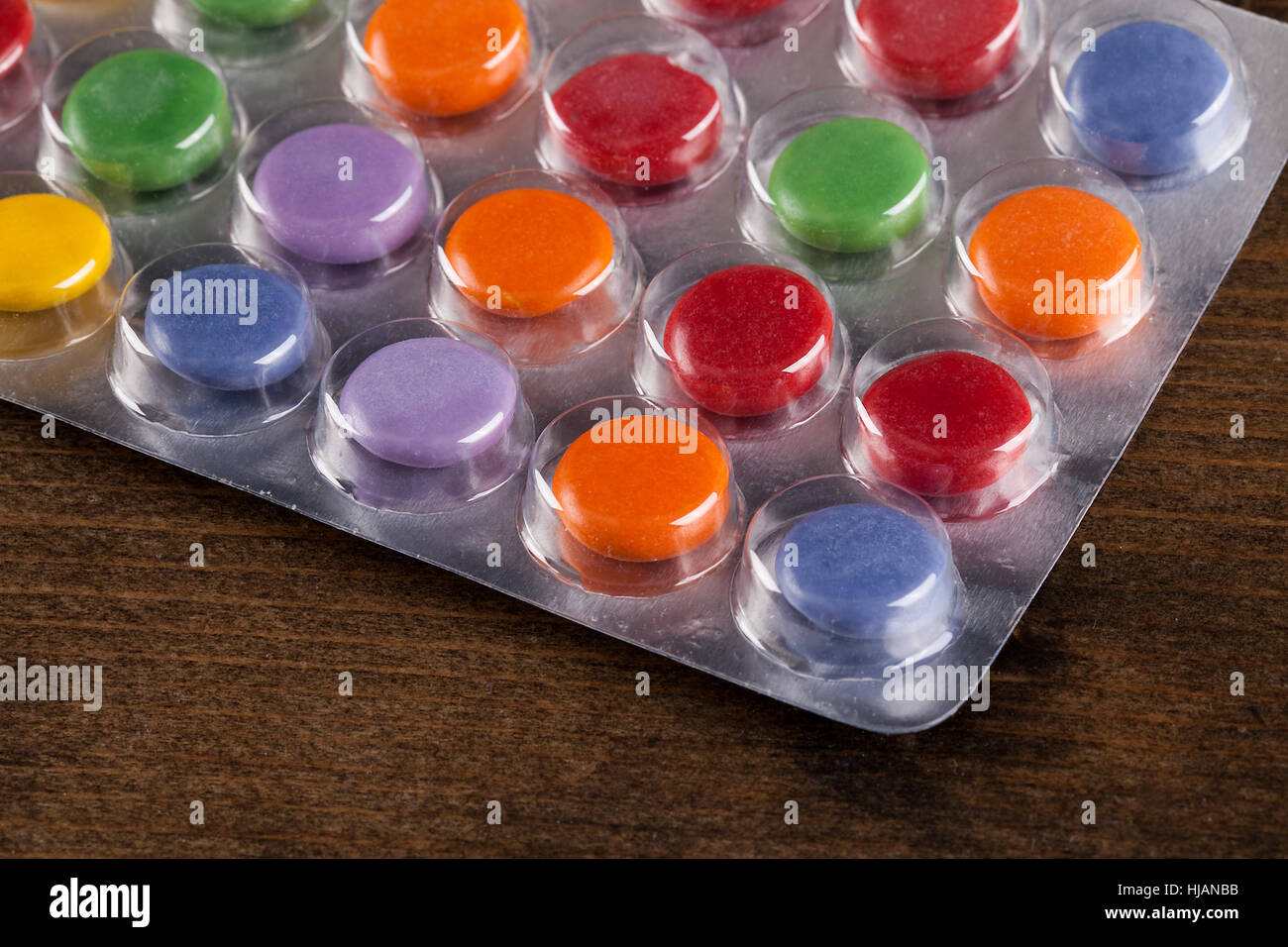 Pills in a bubble pack viewed at an angle. Bright colours and round