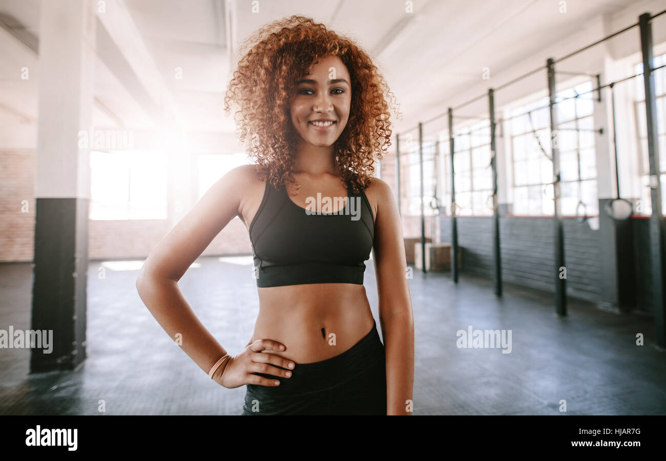 Nice Slim Curly Dark-haired Girl Dressed in Sports Clothes is Sitting on  the Mat for Fitness in the Modern Gym with a Stock Photo - Image of  beautiful, exercise: 144440536