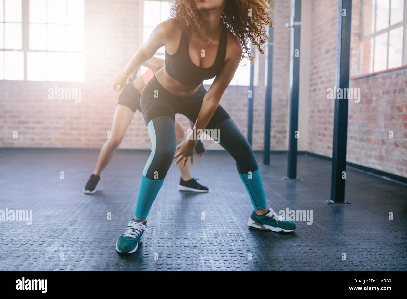 Cropped shot of young females doing running workout in the gym.  Focus on legs of women. Stock Photo