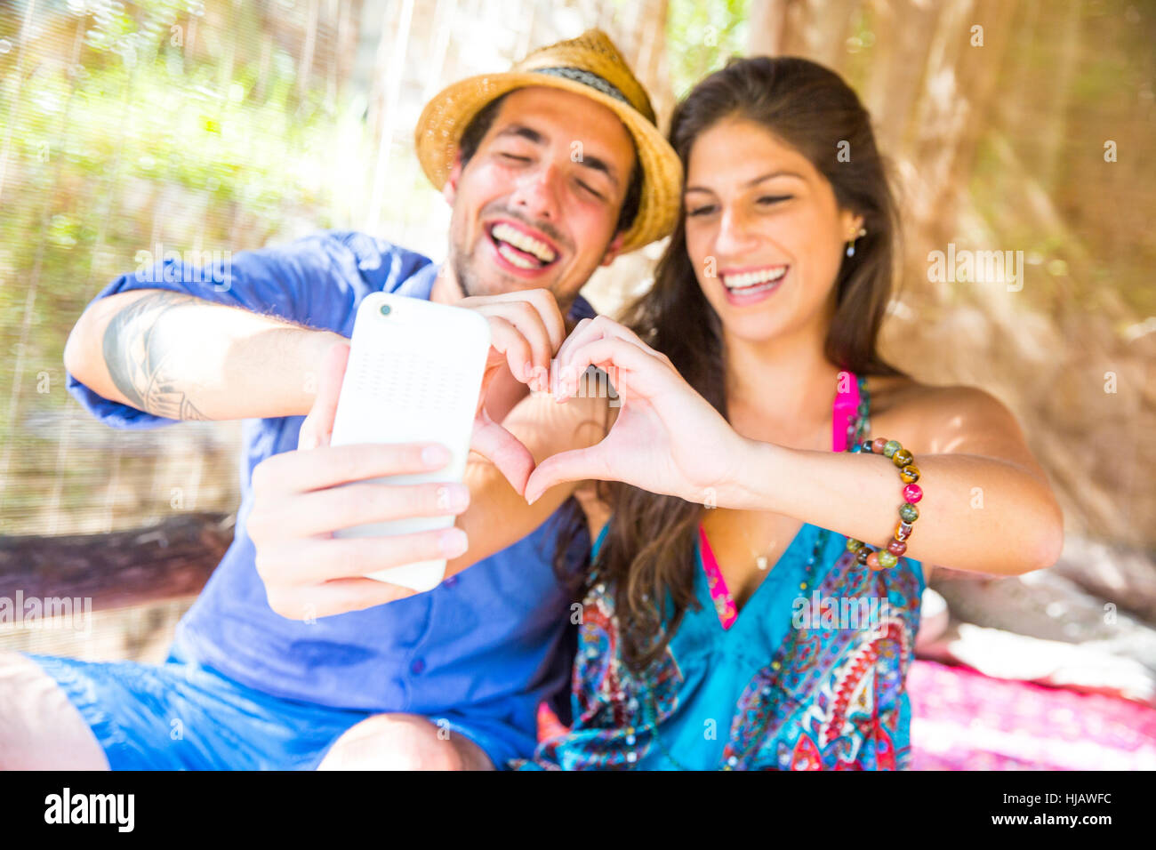 Couple making heart shape with hands taking selfie Stock Photo