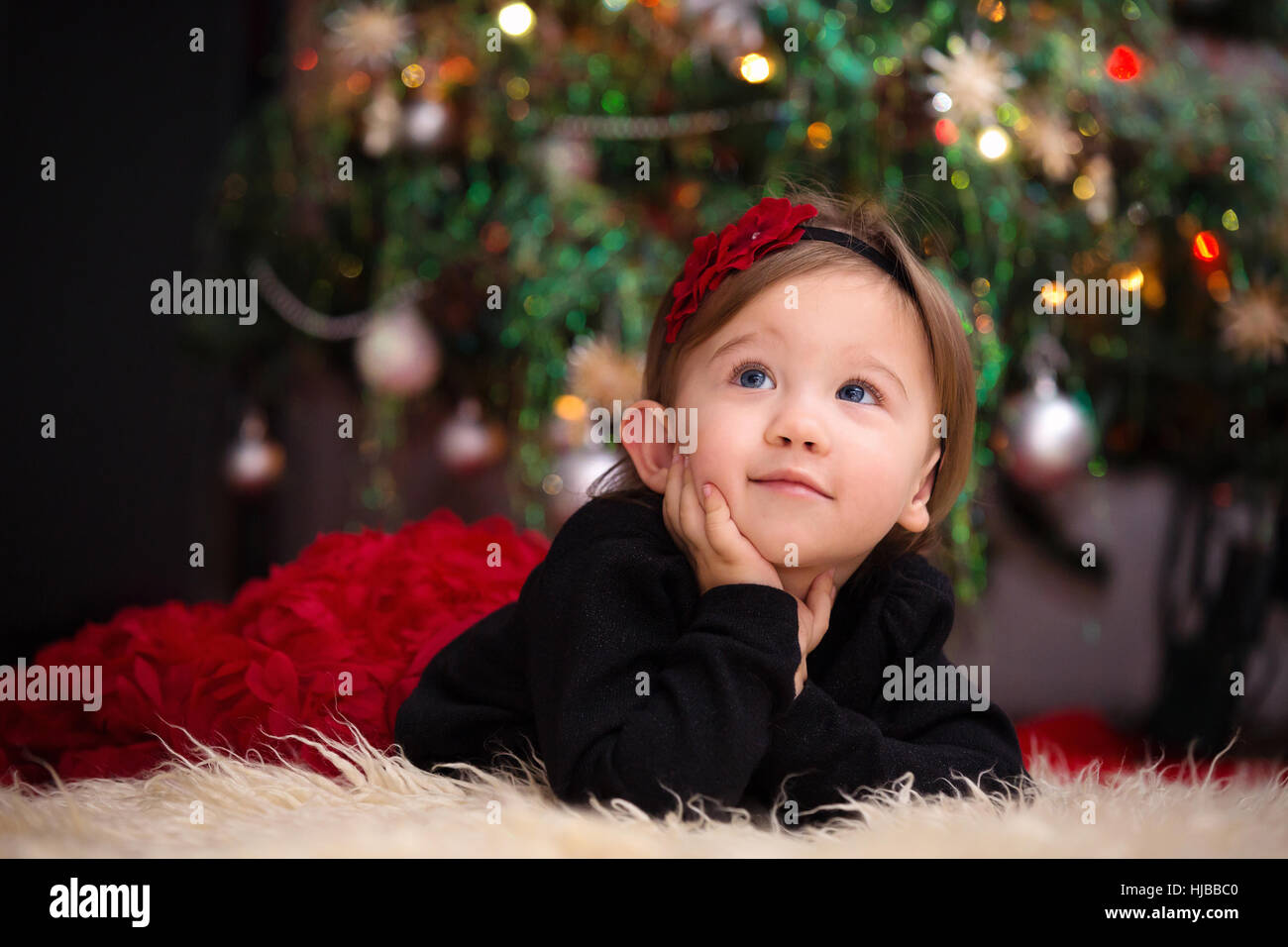 Beautiful Little Girl Looking Up Expecting Her Christmas Gifts Stock Photo