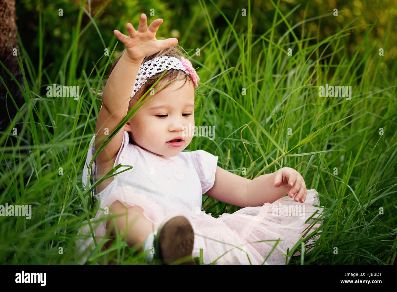 Cute little toddler having fun in the grass Stock Photo