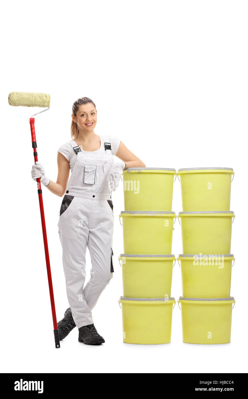 Full length portrait of a female painter holding a paint roller and ...
