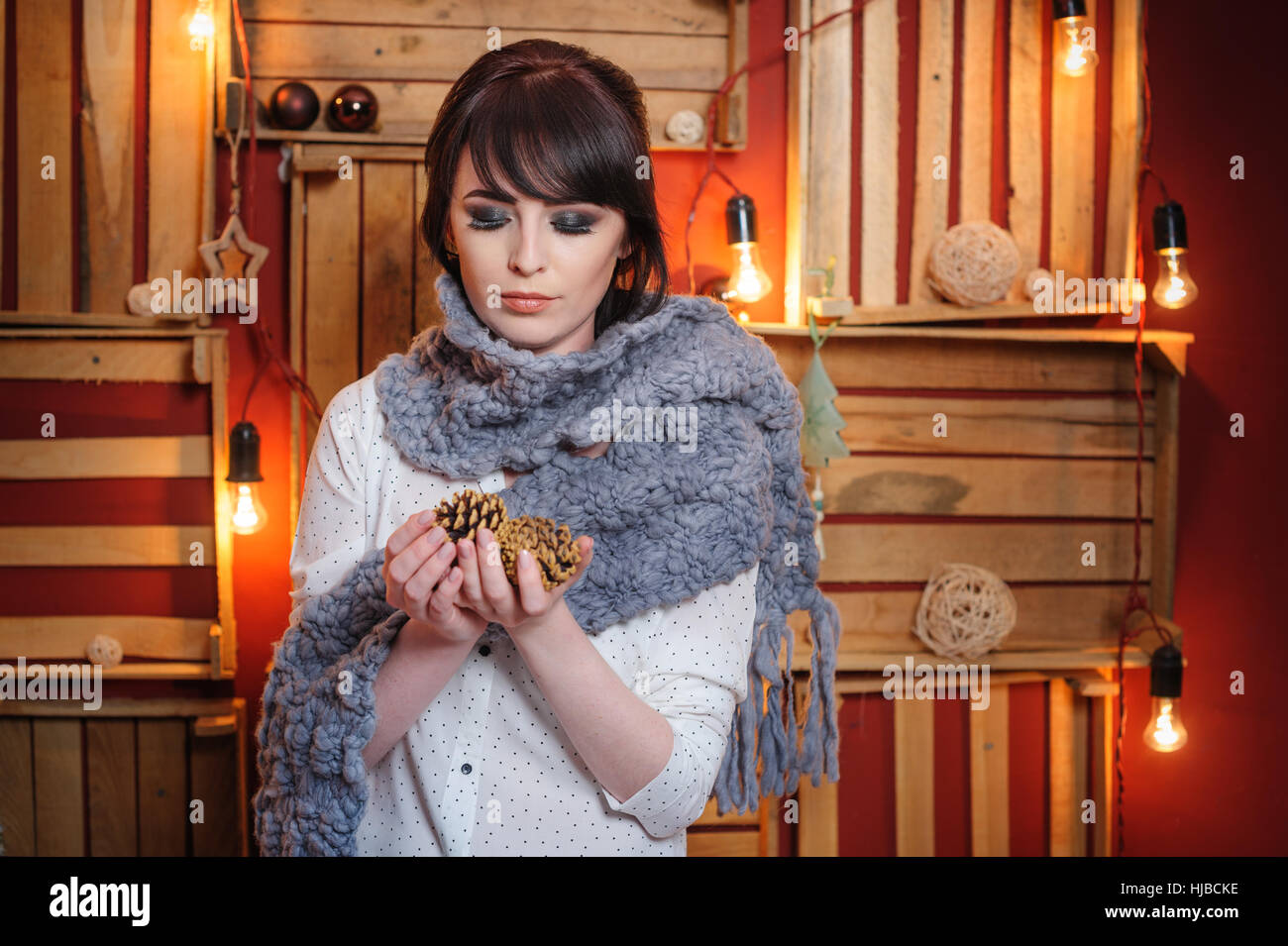 beautiful young woman with grey knitted scarf in the Studio Stock Photo
