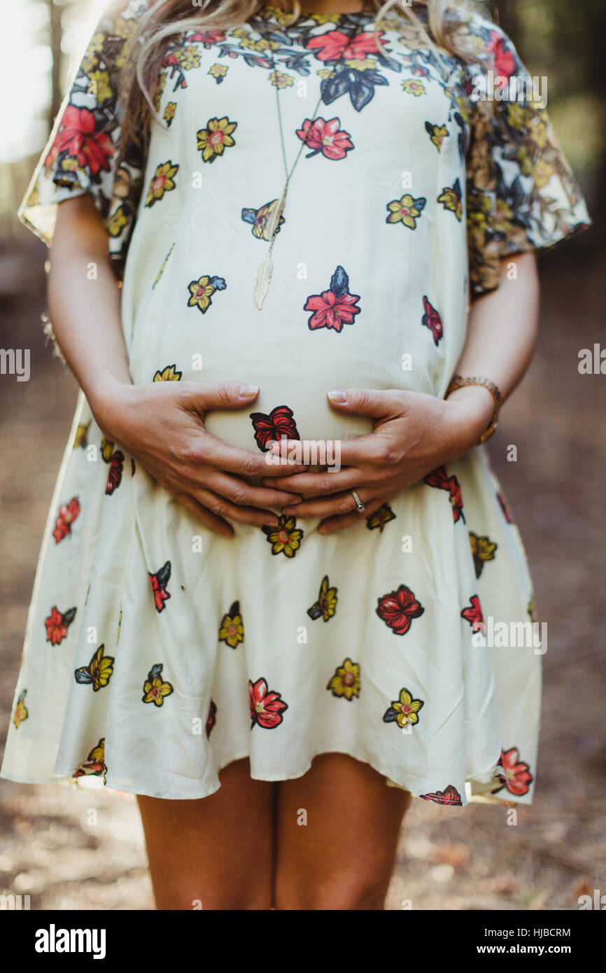 Pregnant woman touching stomach Stock Photo