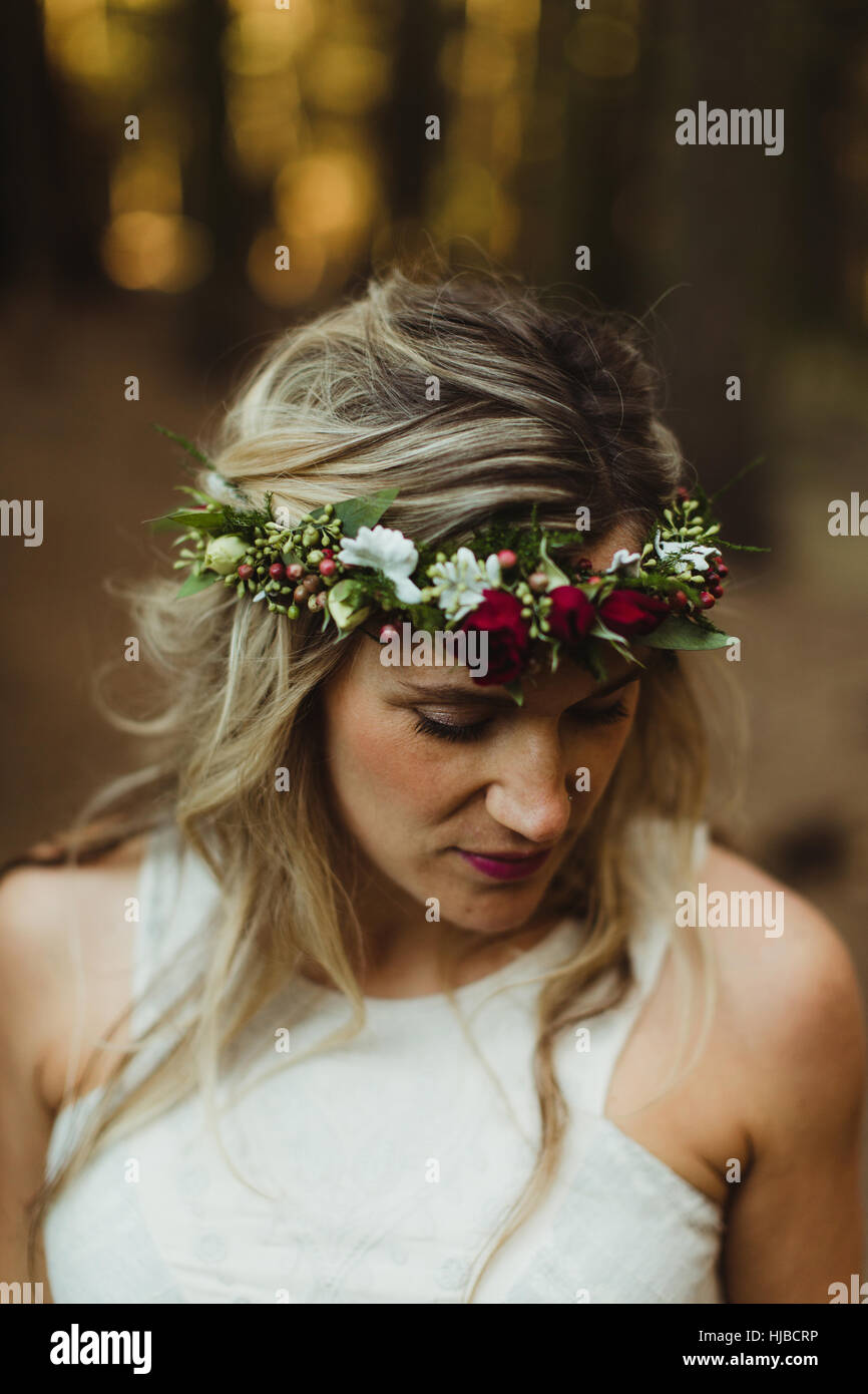 Woman with flowers in hair looking down Stock Photo