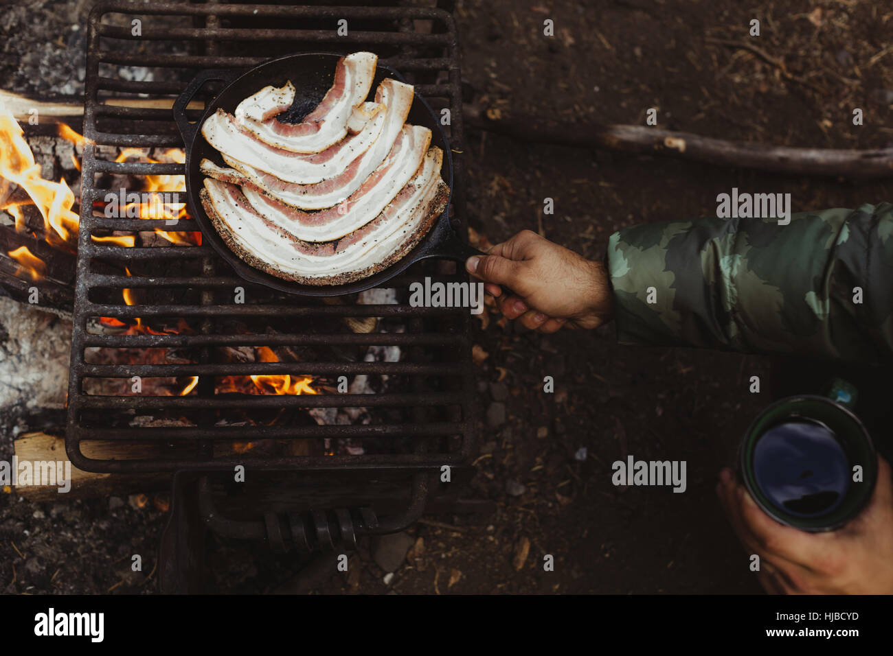 Hands of male hiker frying bacon on campfire, Mineral King, Sequoia National Park, California, USA Stock Photo