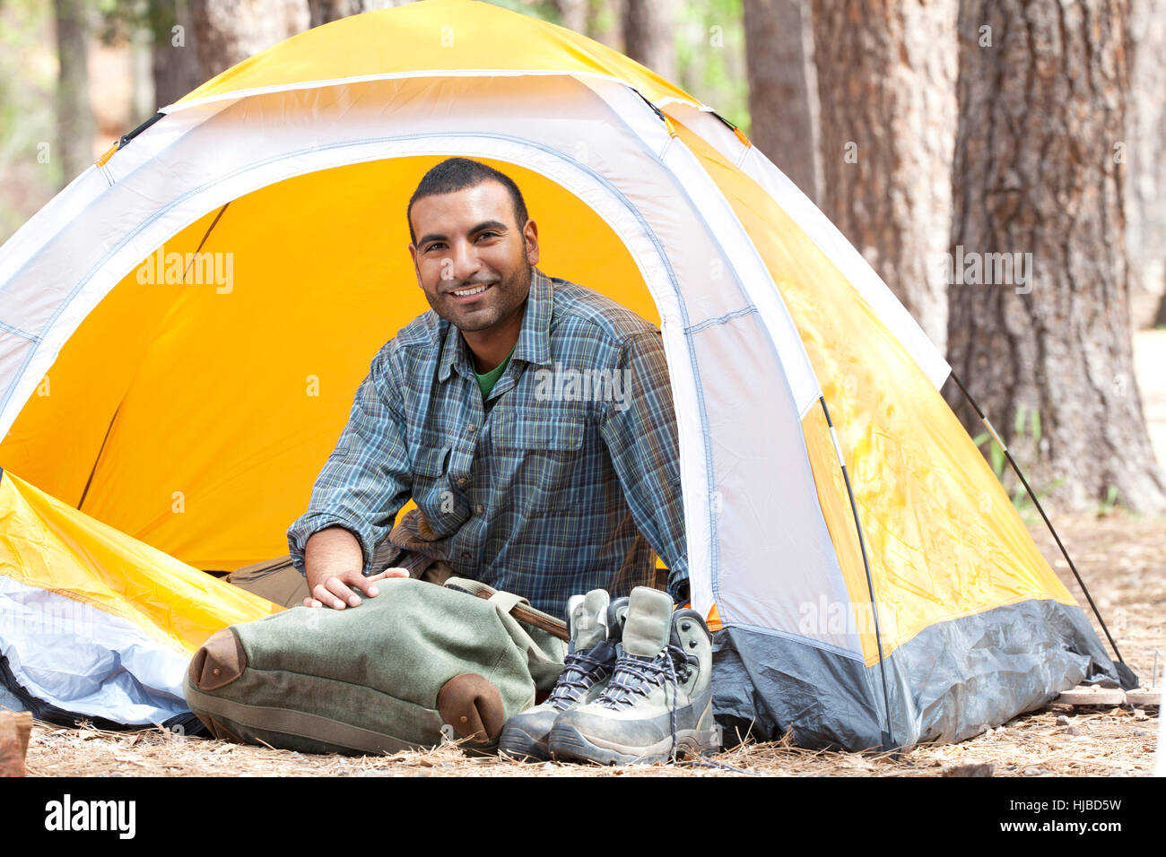 Portrait of young man sitting in dome tent in forest, Sedona, Arizona, USA Stock Photo