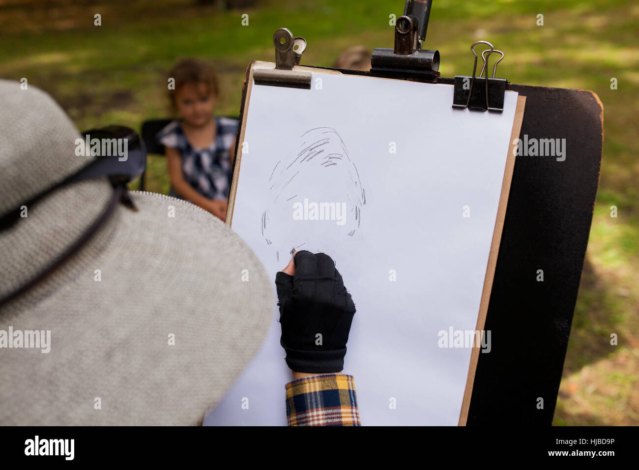 Woman sketching portrait of little girl in background Stock Photo