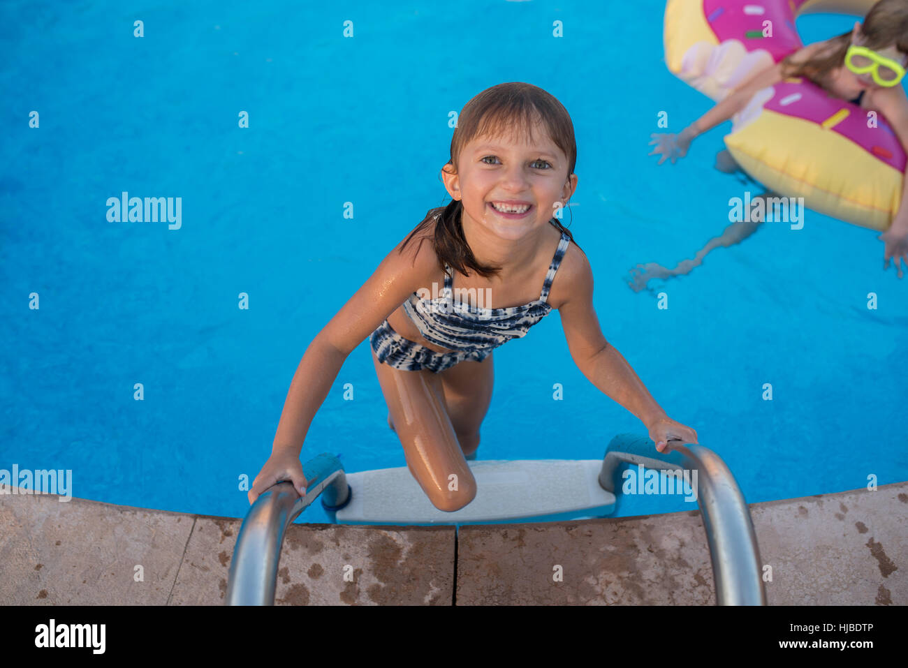 Portrait of young girl climbing out of swimming pool Stock Photo Alamy