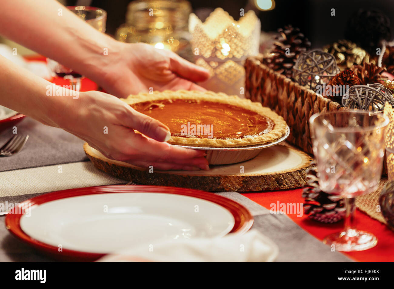 Woman placing pie on festive table Stock Photo