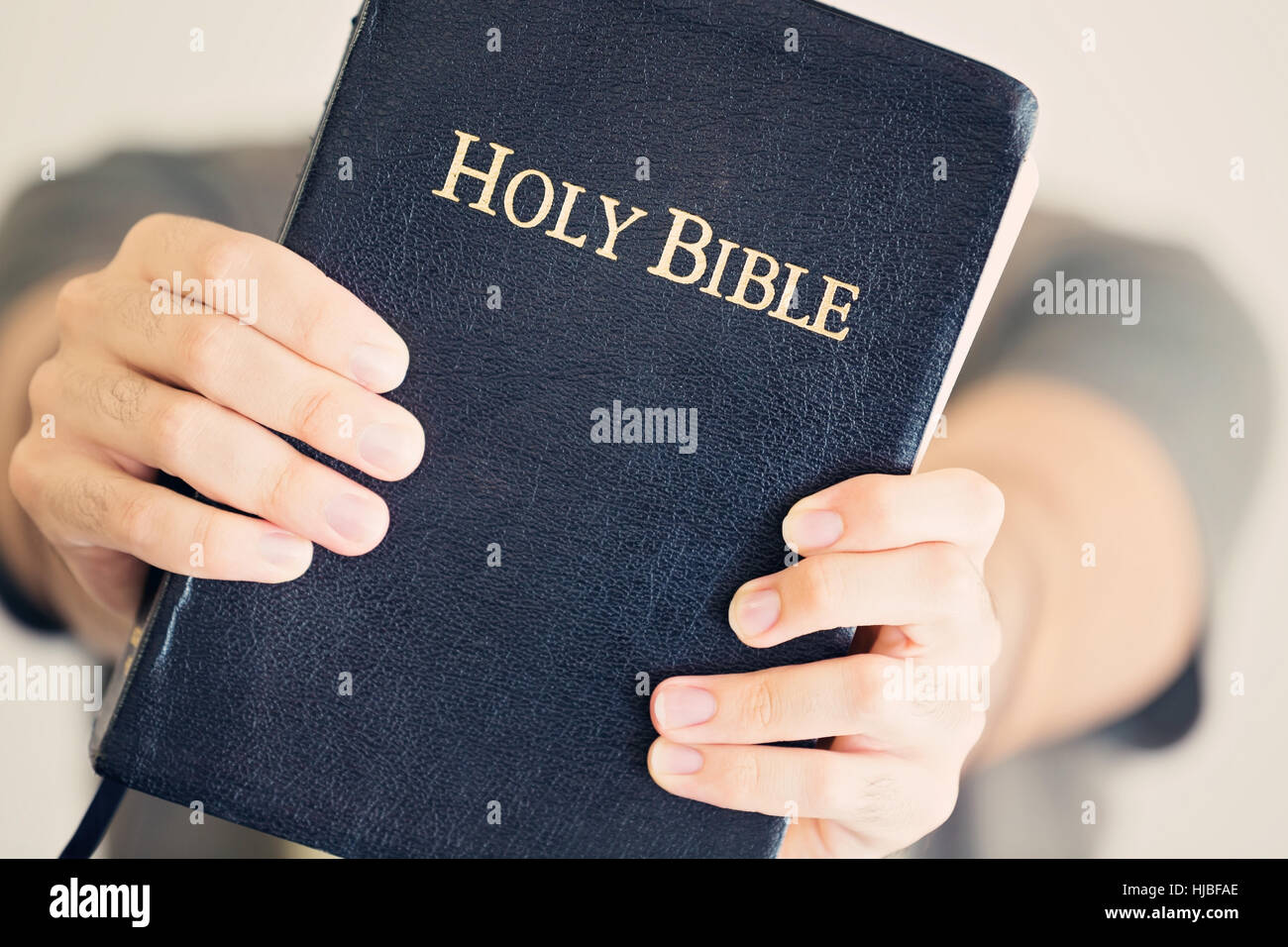 Close up of a young man holding out his Bible Stock Photo