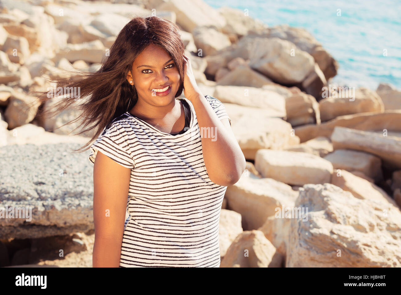 Beautiful young girl smiling in near the water Stock Photo - Alamy