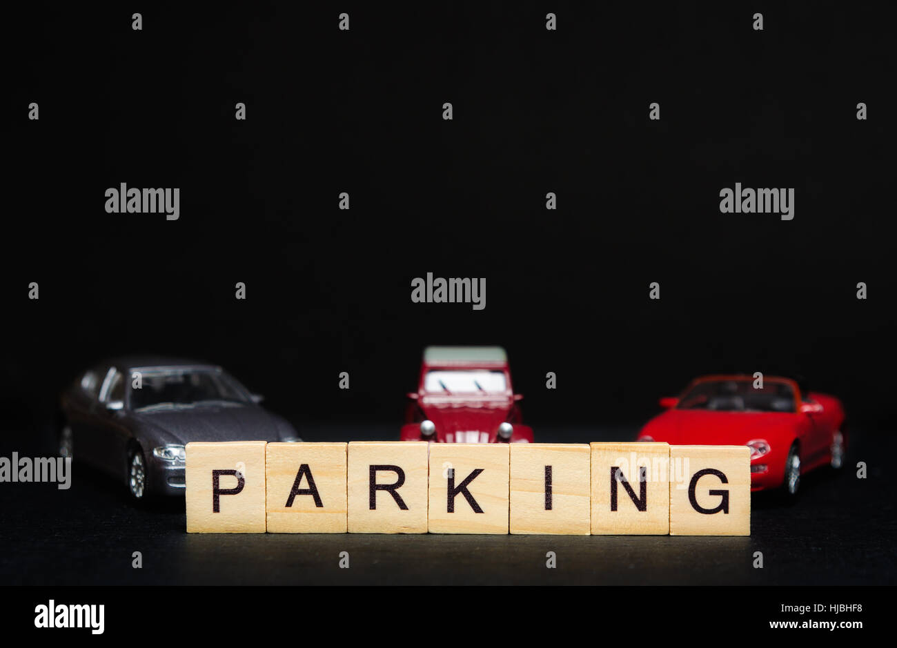 PARKING word written on wood blocks and toys cars in background Stock Photo