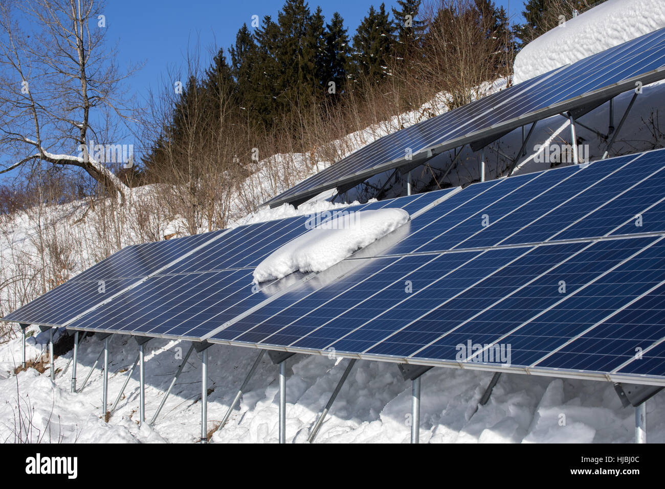 Solar panels in the snow in winter of photovoltaic power station / solar park for the supply of