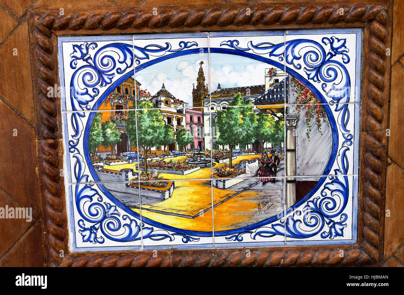 Tile plaque on side of building depicting Plaza Del Triumfo with Giralda Tower in background. Stock Photo