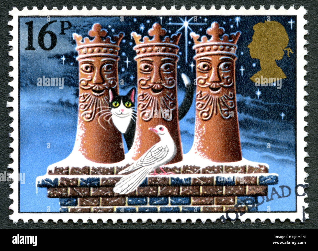 GREAT BRITAIN - CIRCA 1983: A used postage stamp from the UK, depicting a festive illustration of a cat and dove on a rooftop with Chimneys, circa 198 Stock Photo