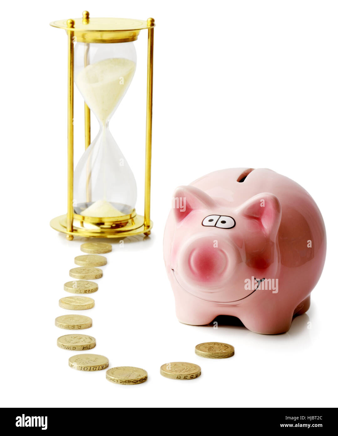 Concept of time and money with a piggybank and hourglass isolated on a white background Stock Photo