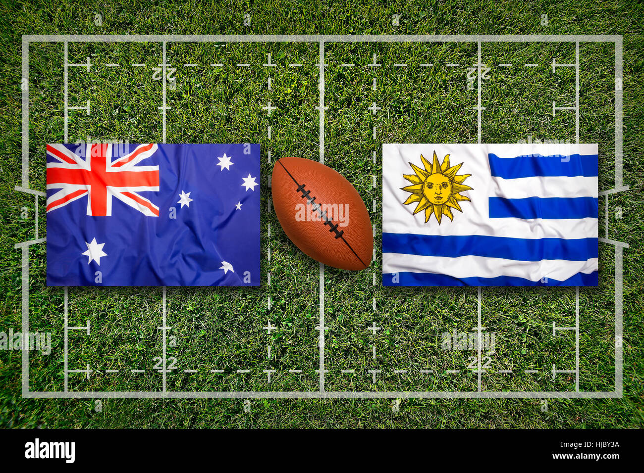 Australia vs. Uruguay flags on green rugby field Stock Photo