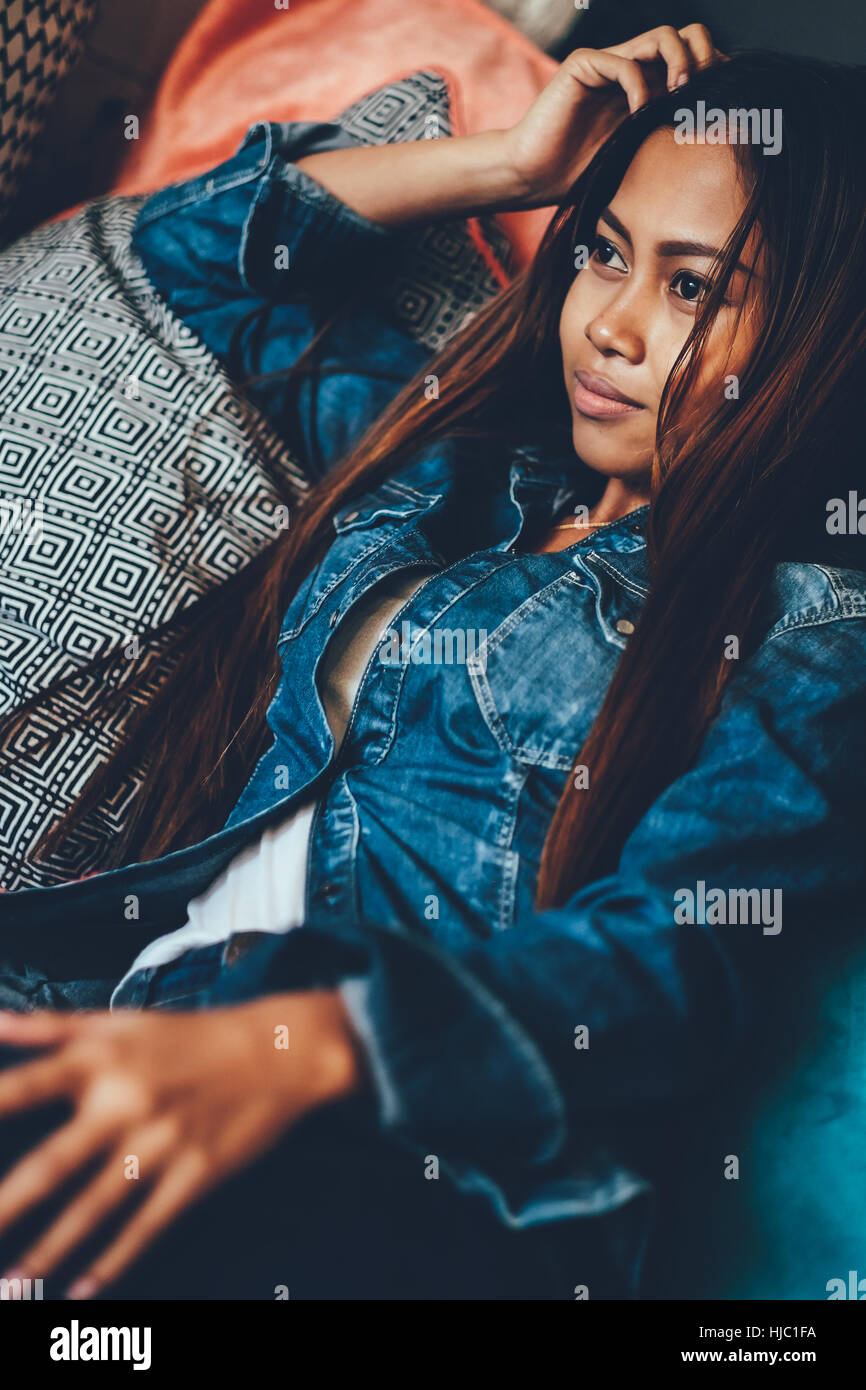 Gorgeous young woman in blue jeans chilling in a club Stock Photo