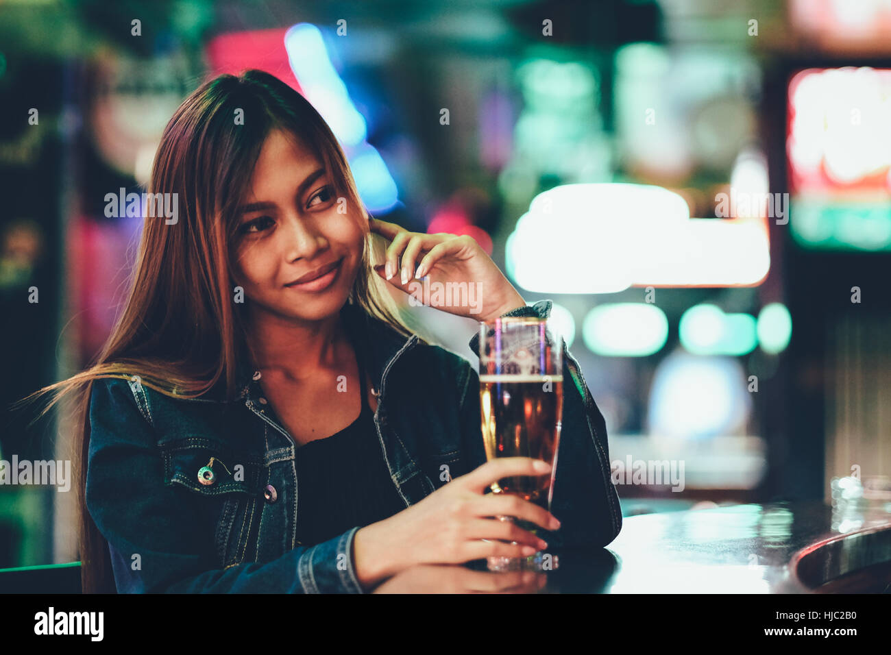 Night life, adult girl waiting in the Bar drinking bear Stock Photo