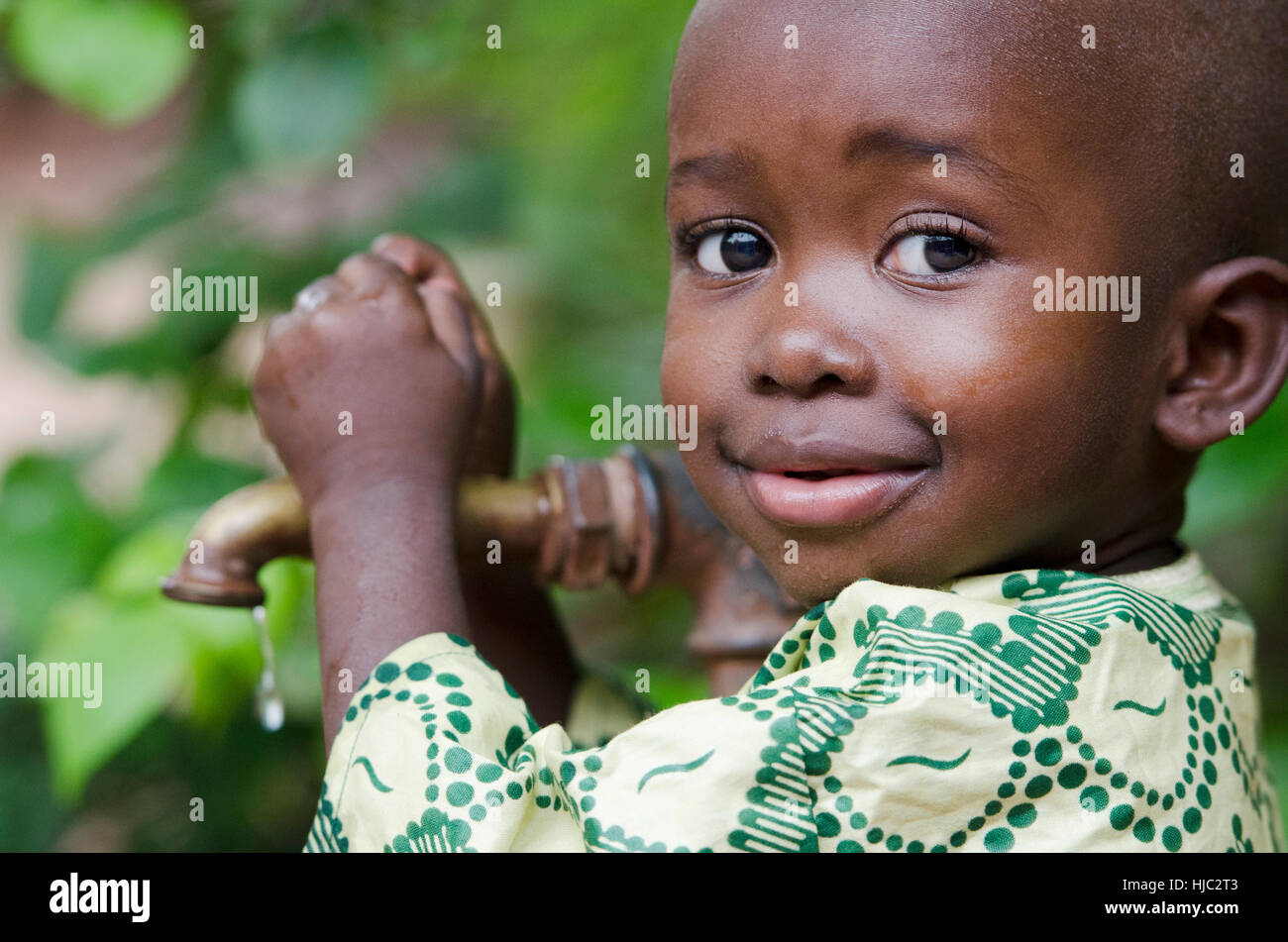 Little black boy asking begging for clean water. Its scarcity affects every continent. Around 1 billion people, live in areas of physical scarcity, an Stock Photo