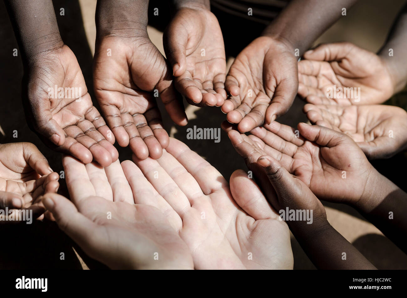 Caucasian and African Ethnicity Hands Asking for Help Symbol Stock Photo