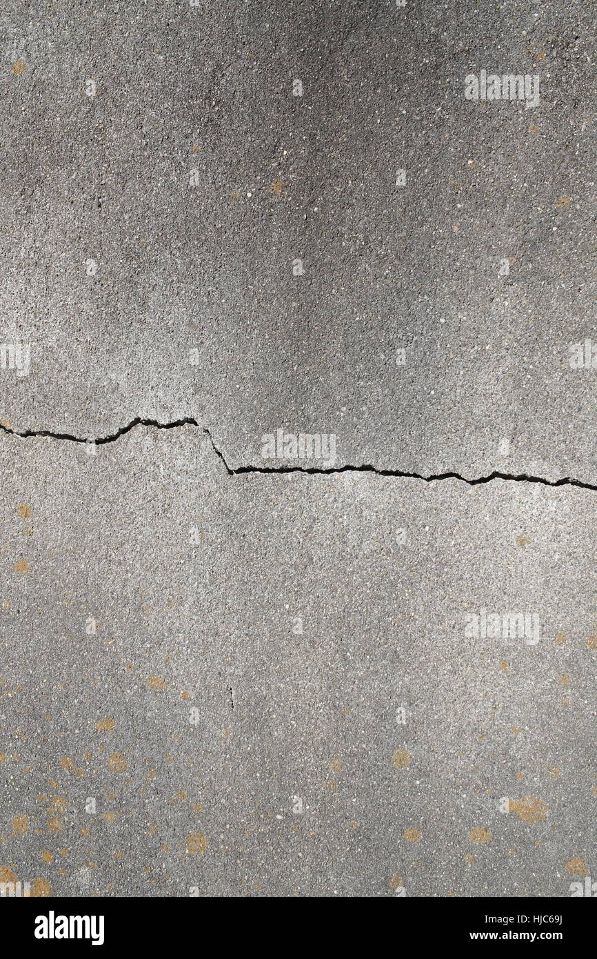 Crack in the structure of a grey concrete wall Stock Photo