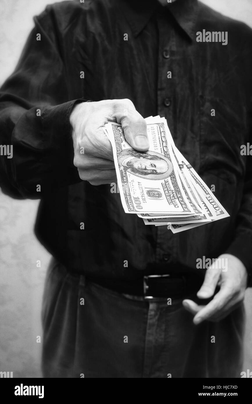 Corrupted businessman, or politician, offering a Dollar banknotes bribe Stock Photo
