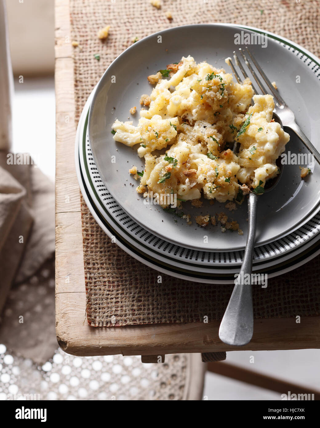 Bistro table with stacked plates and macaroni cheese Stock Photo
